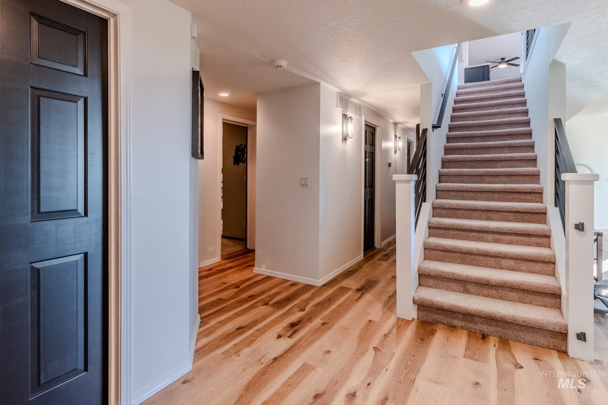 Staircase with wood finished floors, recessed lighting, and ceiling fan