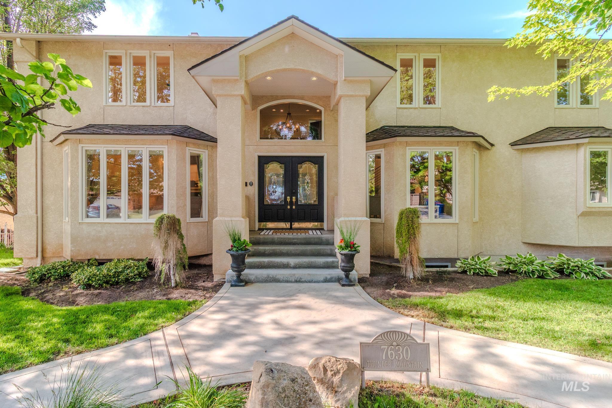 Doorway to property featuring french doors, stucco siding, and roof with shingles