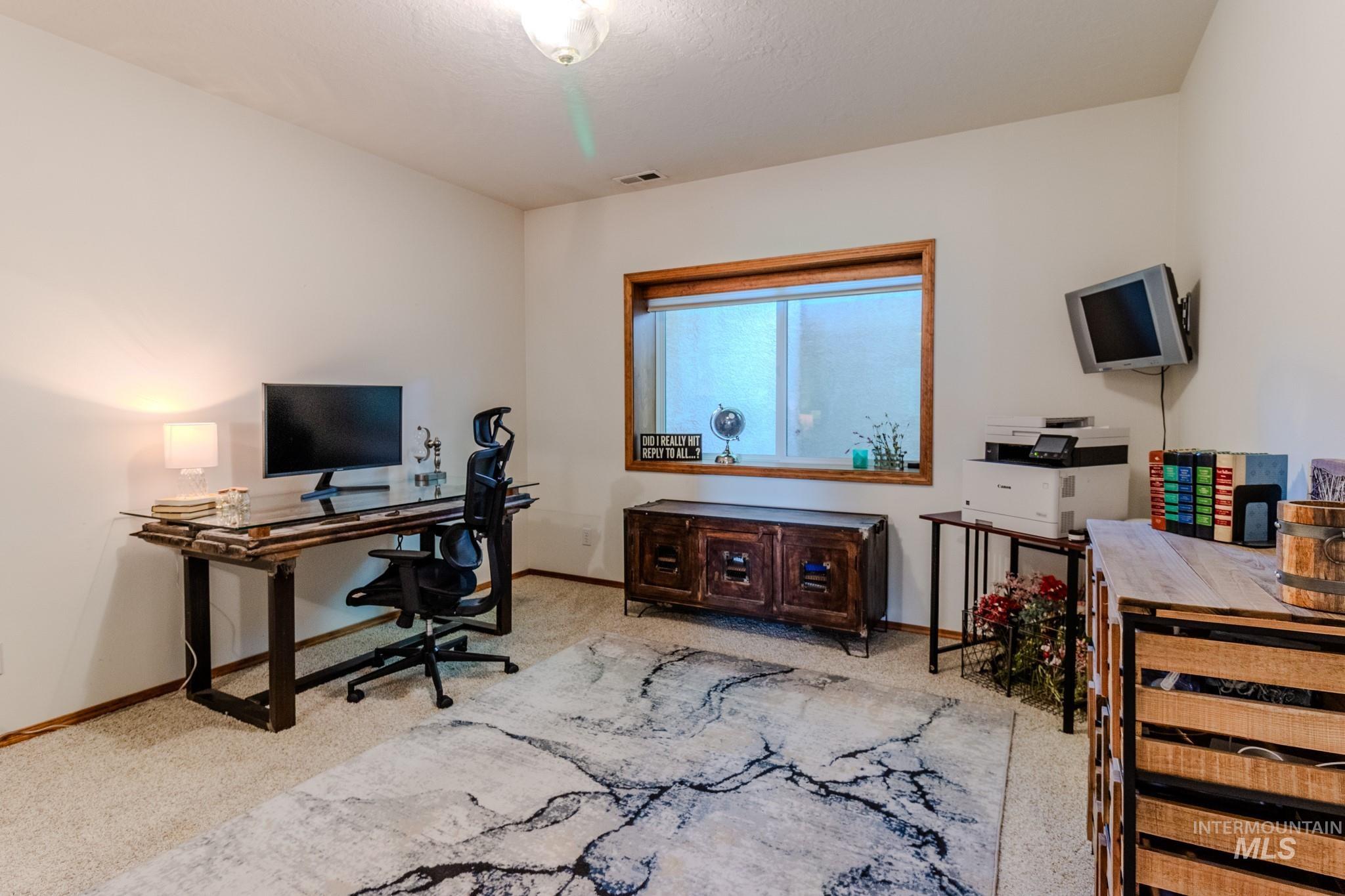 Home office featuring carpet flooring and baseboards