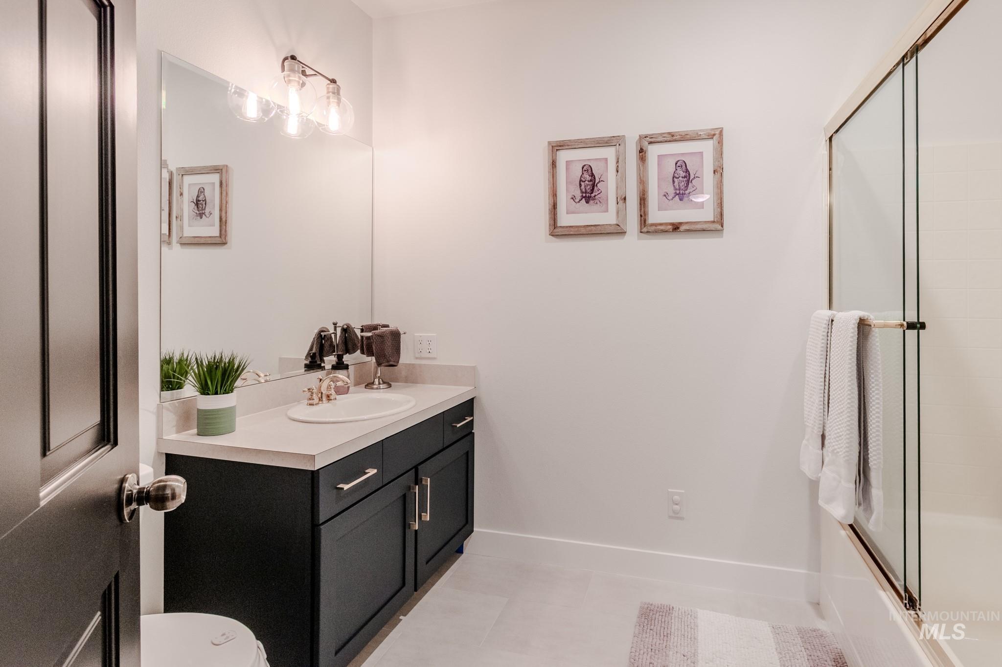 Full bath with vanity and enclosed tub / shower combo