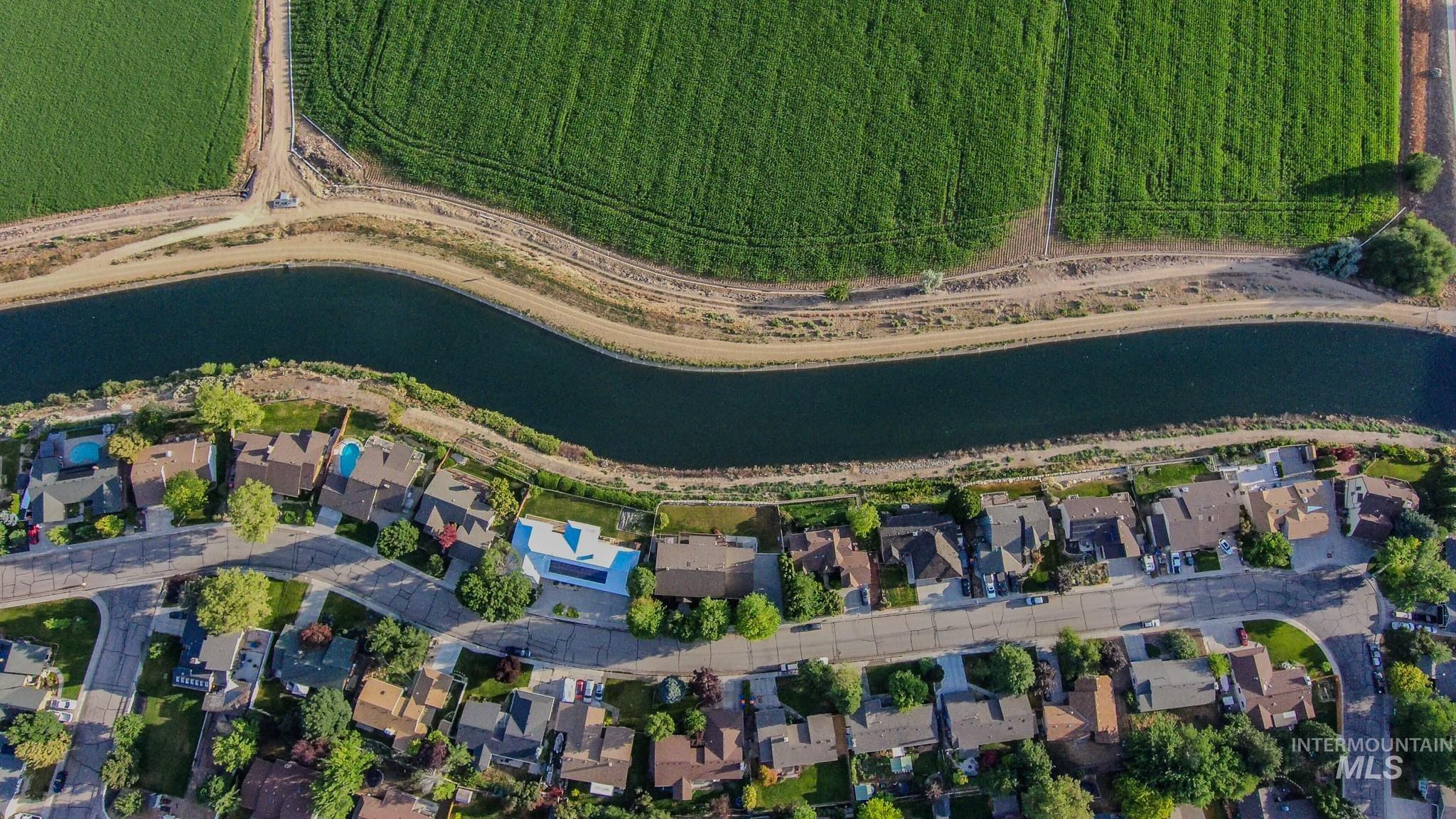 Aerial view of property and surrounding area featuring a large body of water and nearby suburban area