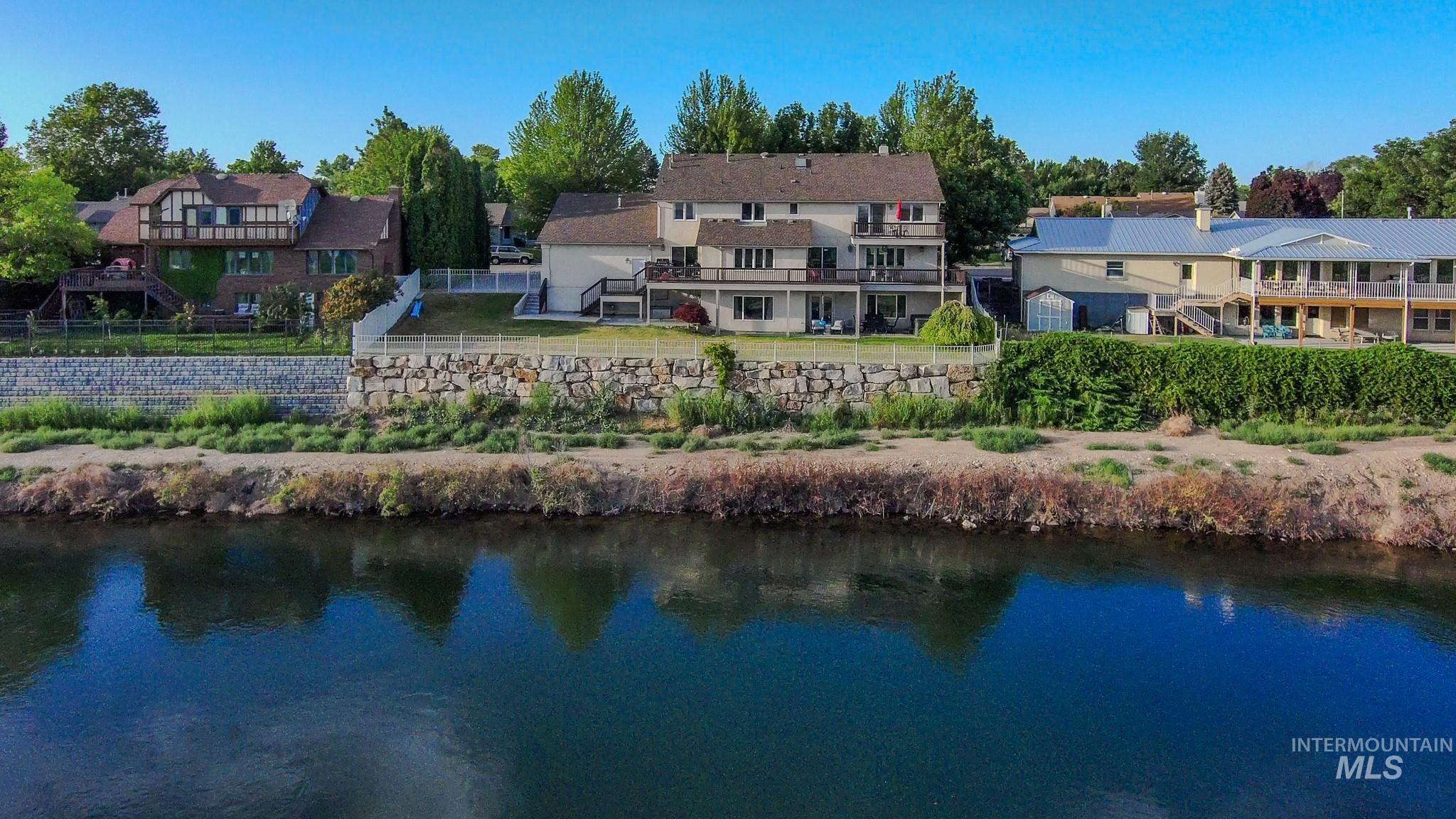 Water view with nearby suburban area and a fenced backyard