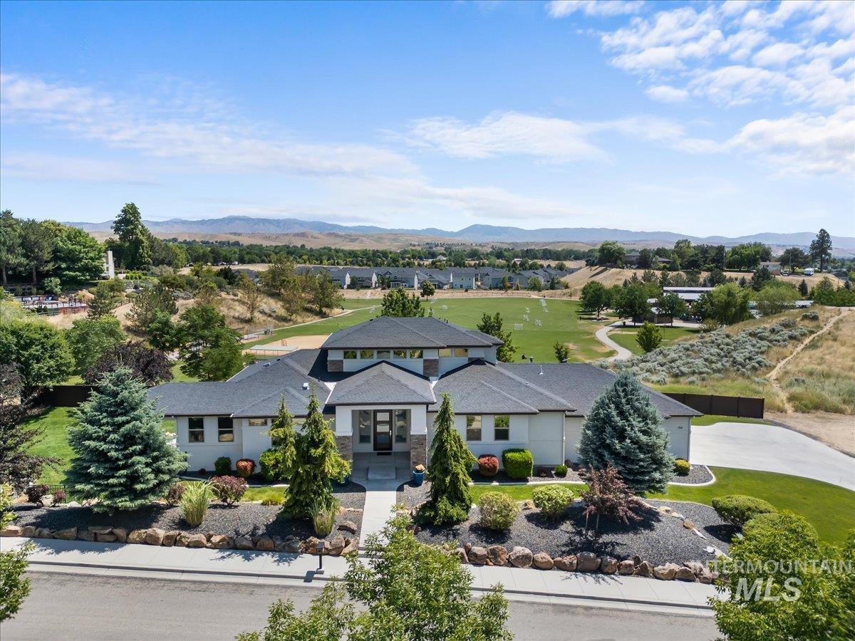 Aerial view of property and surrounding area with a mountain backdrop