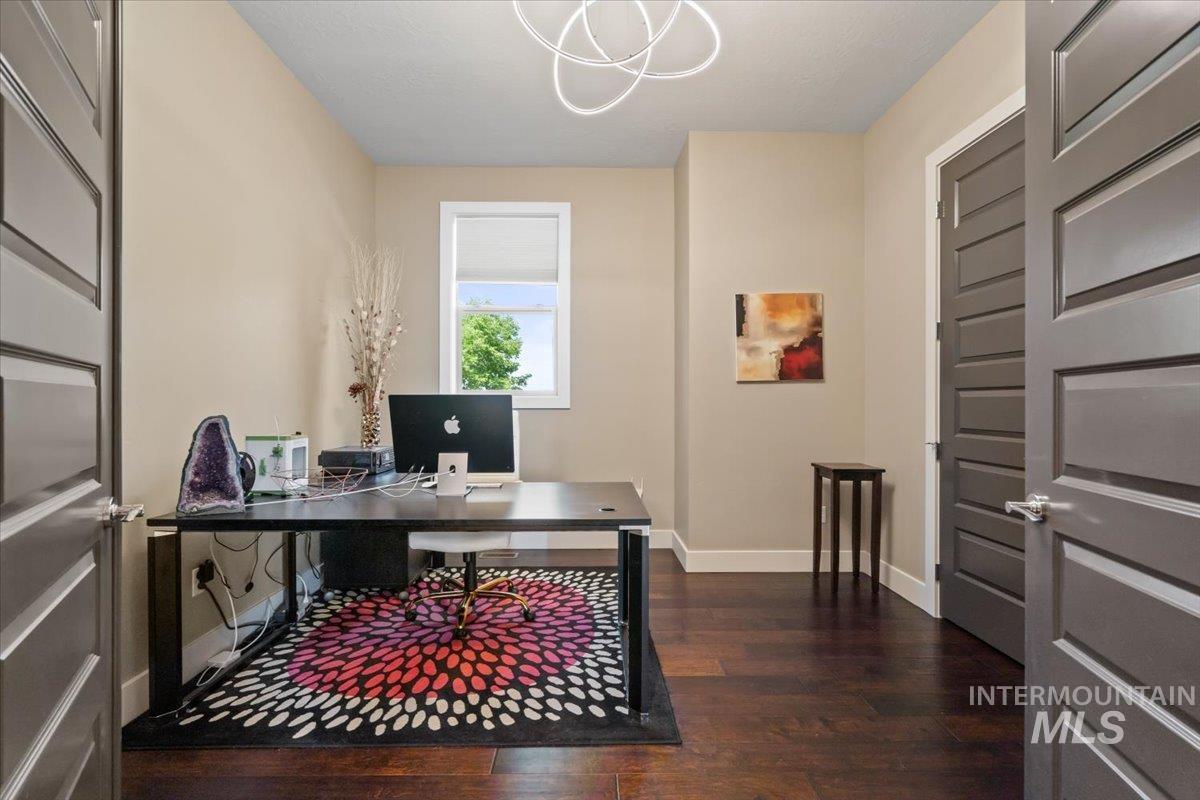 Office with dark wood-style flooring and baseboards