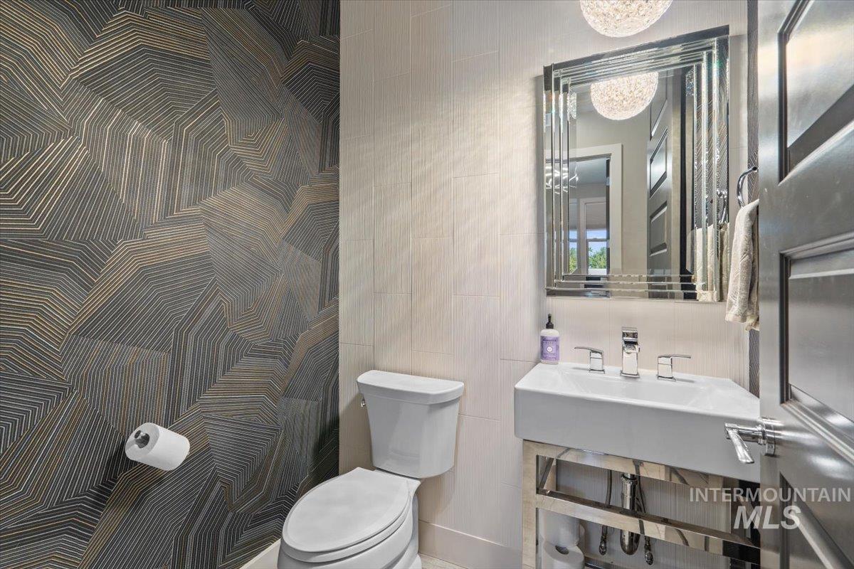 Bathroom featuring a chandelier and tile walls