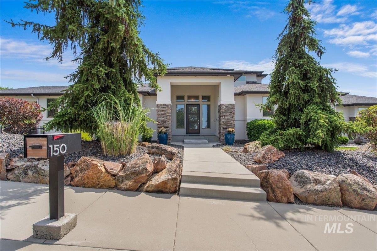 View of front of house with stucco siding and stone siding