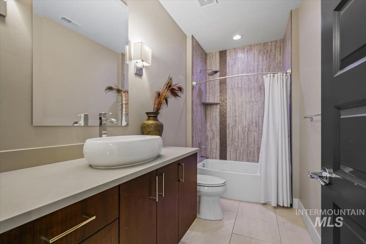 Bathroom featuring vanity, tile patterned flooring, and shower / bath combination with curtain