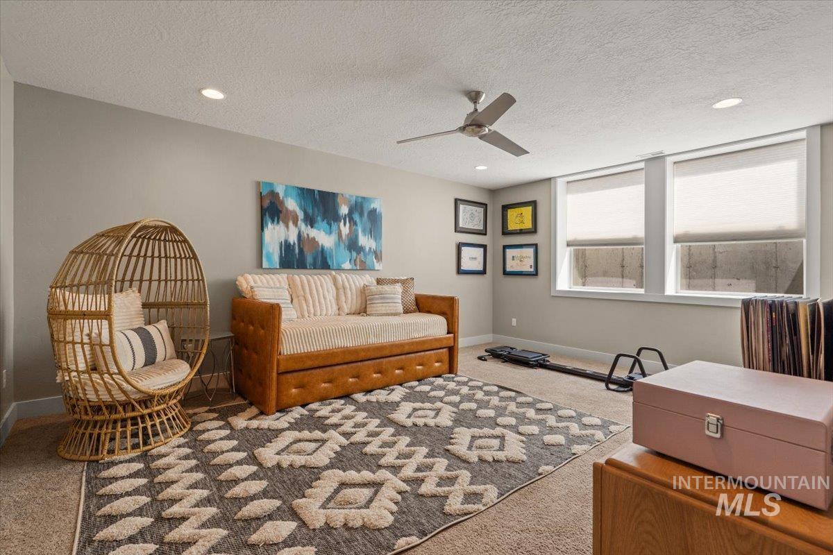 Living area featuring carpet flooring, a ceiling fan, recessed lighting, and a textured ceiling