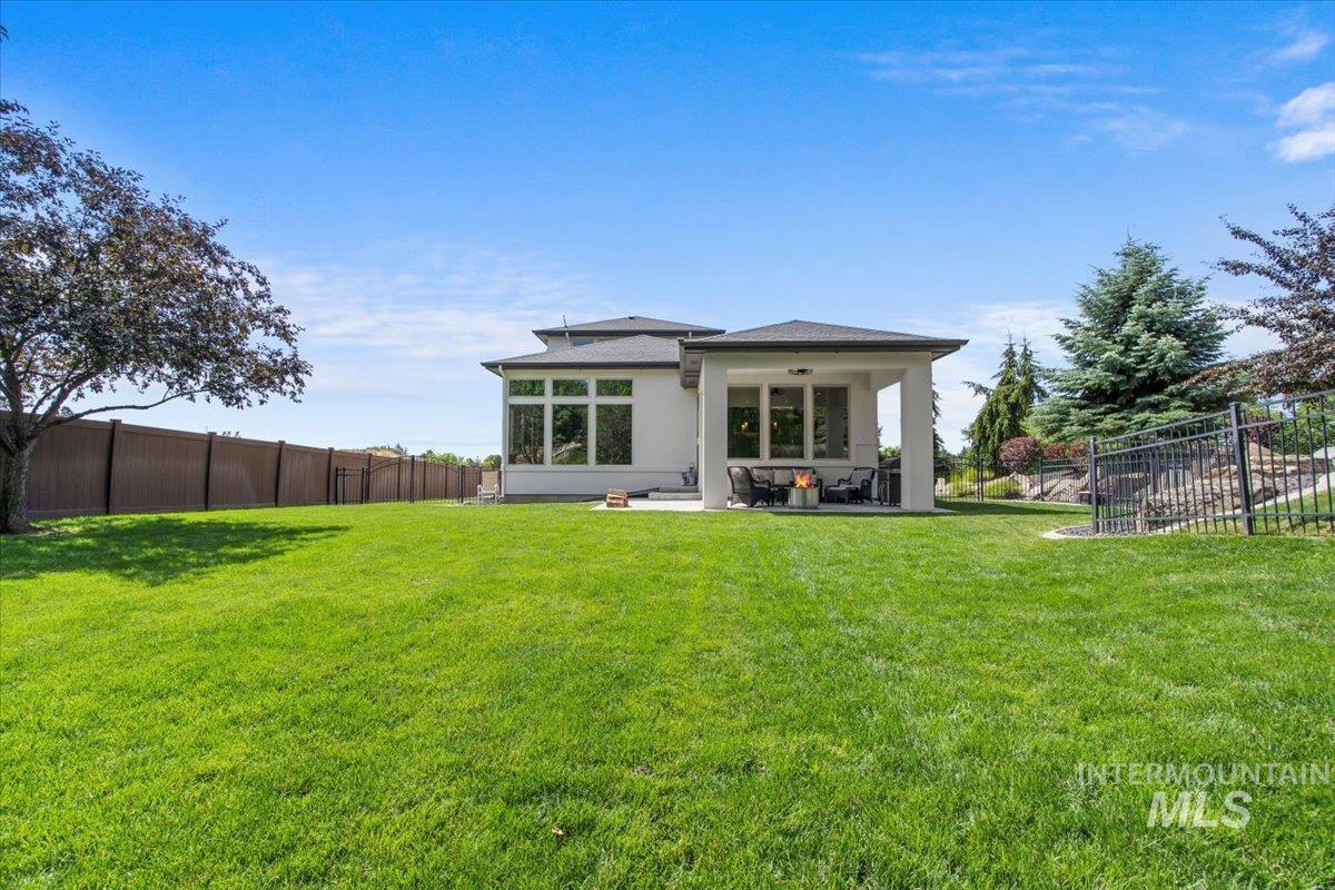 Back of property with a fenced backyard, stucco siding, and a patio area