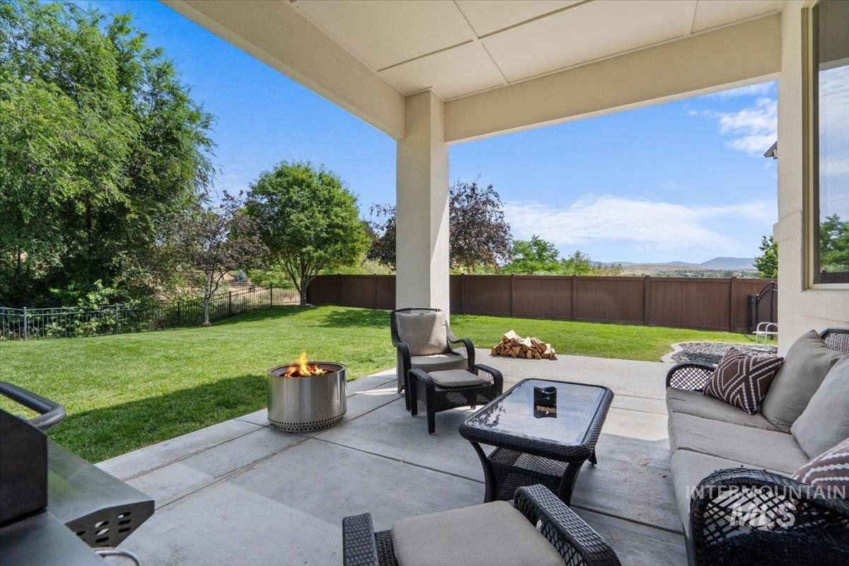 Fenced backyard featuring a patio area and an outdoor living space with a fire pit