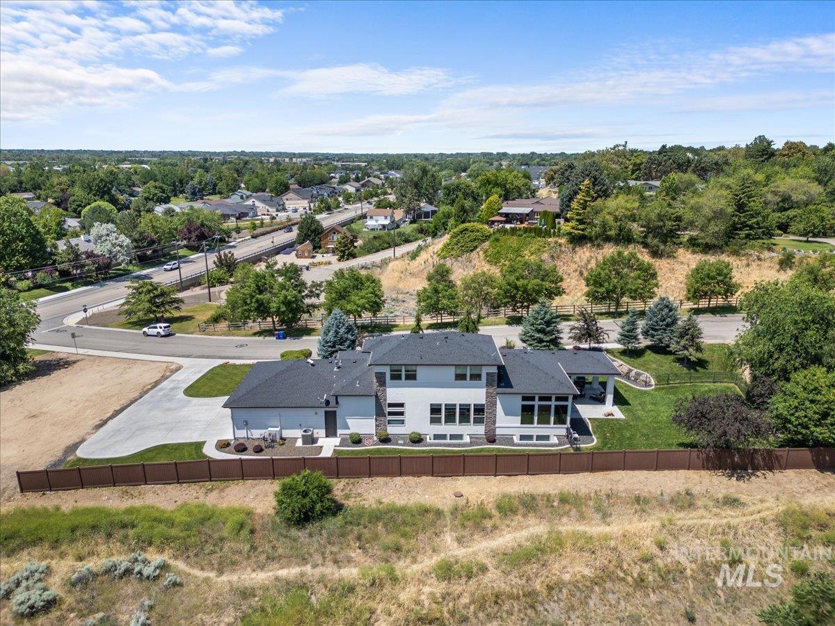 Aerial view of property and surrounding area with a tree filled landscape