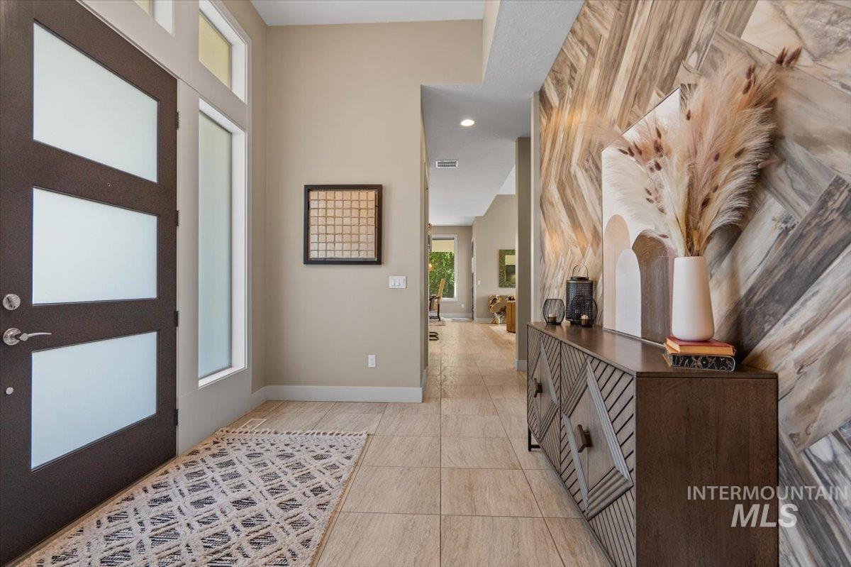 Entryway with light tile patterned floors and recessed lighting