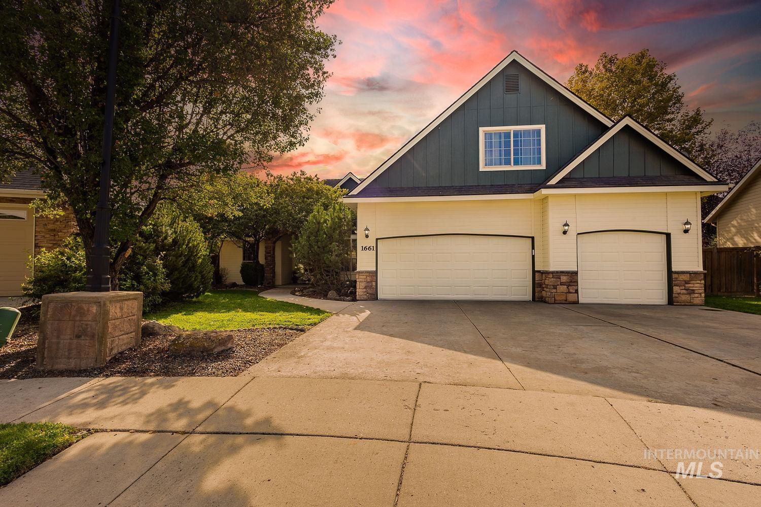 Craftsman-style home featuring stone siding, driveway, board and batten siding, and a garage