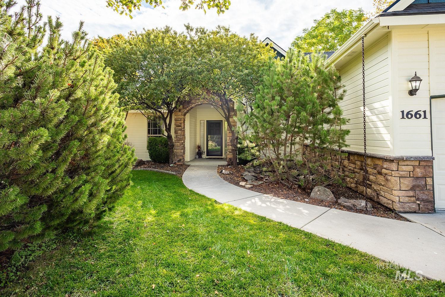 View of front facade featuring stone siding and a front yard
