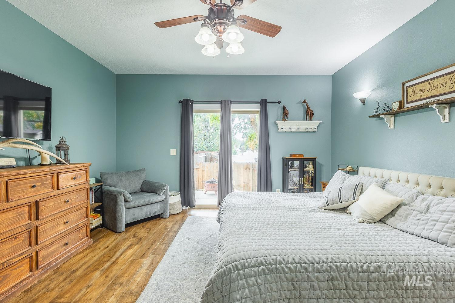 Bedroom with light wood-style flooring, access to exterior, and a ceiling fan