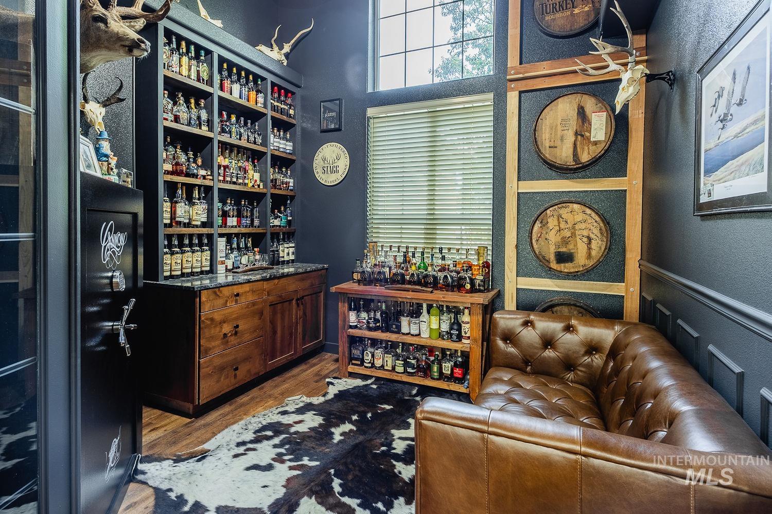 Wine room featuring a community bar and wood finished floors