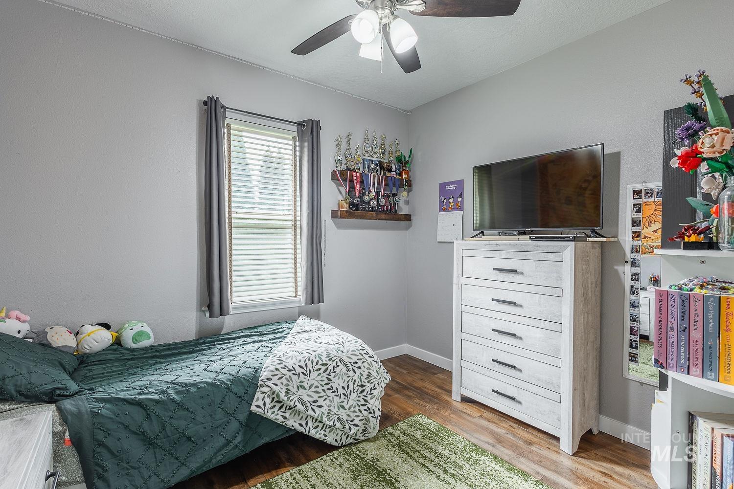 Bedroom featuring wood finished floors and ceiling fan