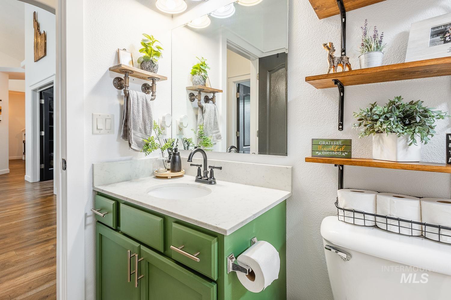 Bathroom featuring vanity, wood finished floors, and a textured wall