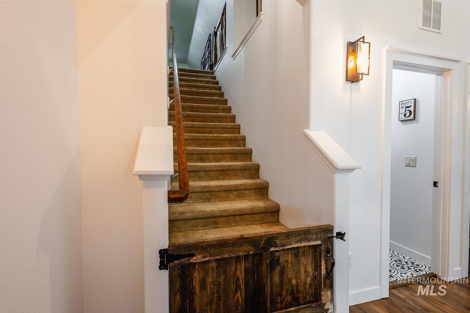 Staircase featuring wood finished floors and baseboards