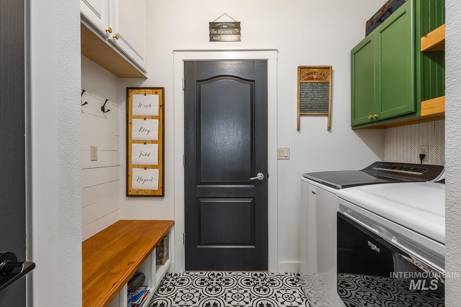 Laundry room with washer and clothes dryer and tile patterned floors