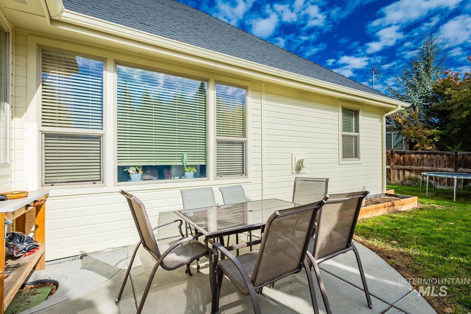 View of patio with a trampoline and outdoor dining area