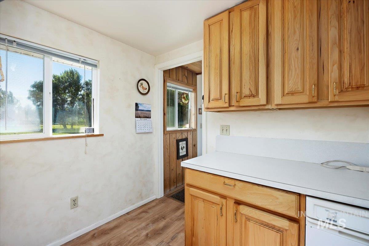 Kitchen with light countertops, light wood-style floors, dishwasher, and light brown cabinets