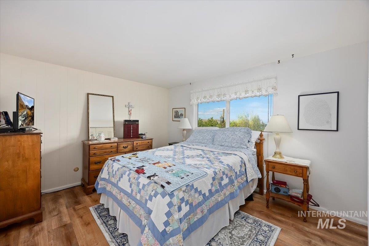Bedroom with wood finished floors and baseboards