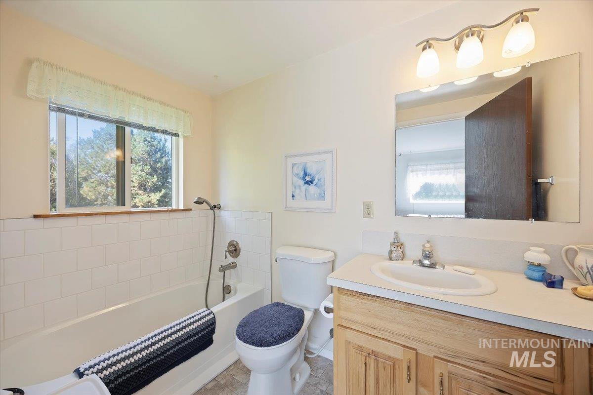 Full bathroom with vanity, plenty of natural light, and tub / shower combination