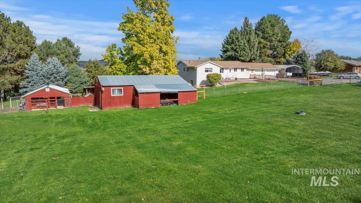 View of yard with a pole building and an outdoor structure