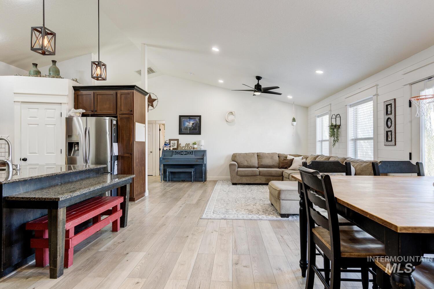 Dining space featuring light wood-style floors, lofted ceiling, ceiling fan, and recessed lighting