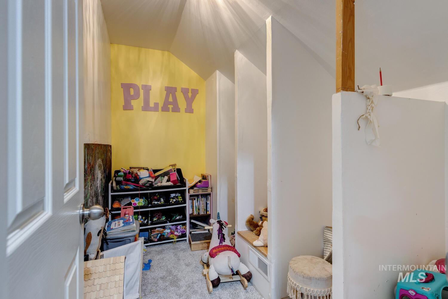 Rec room with light colored carpet and vaulted ceiling