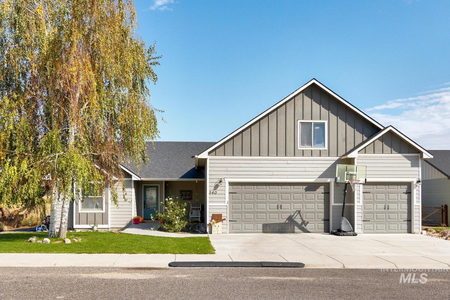 Craftsman inspired home with board and batten siding, driveway, a shingled roof, and a front yard