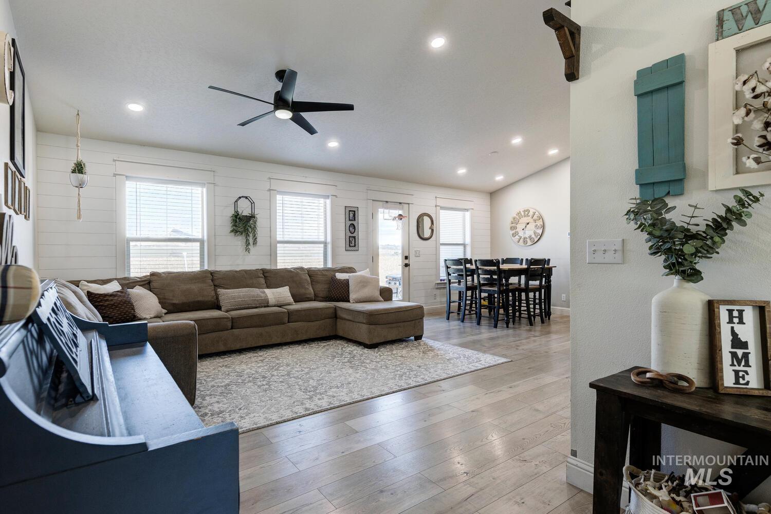 Living area with plenty of natural light, light wood-style floors, recessed lighting, and ceiling fan