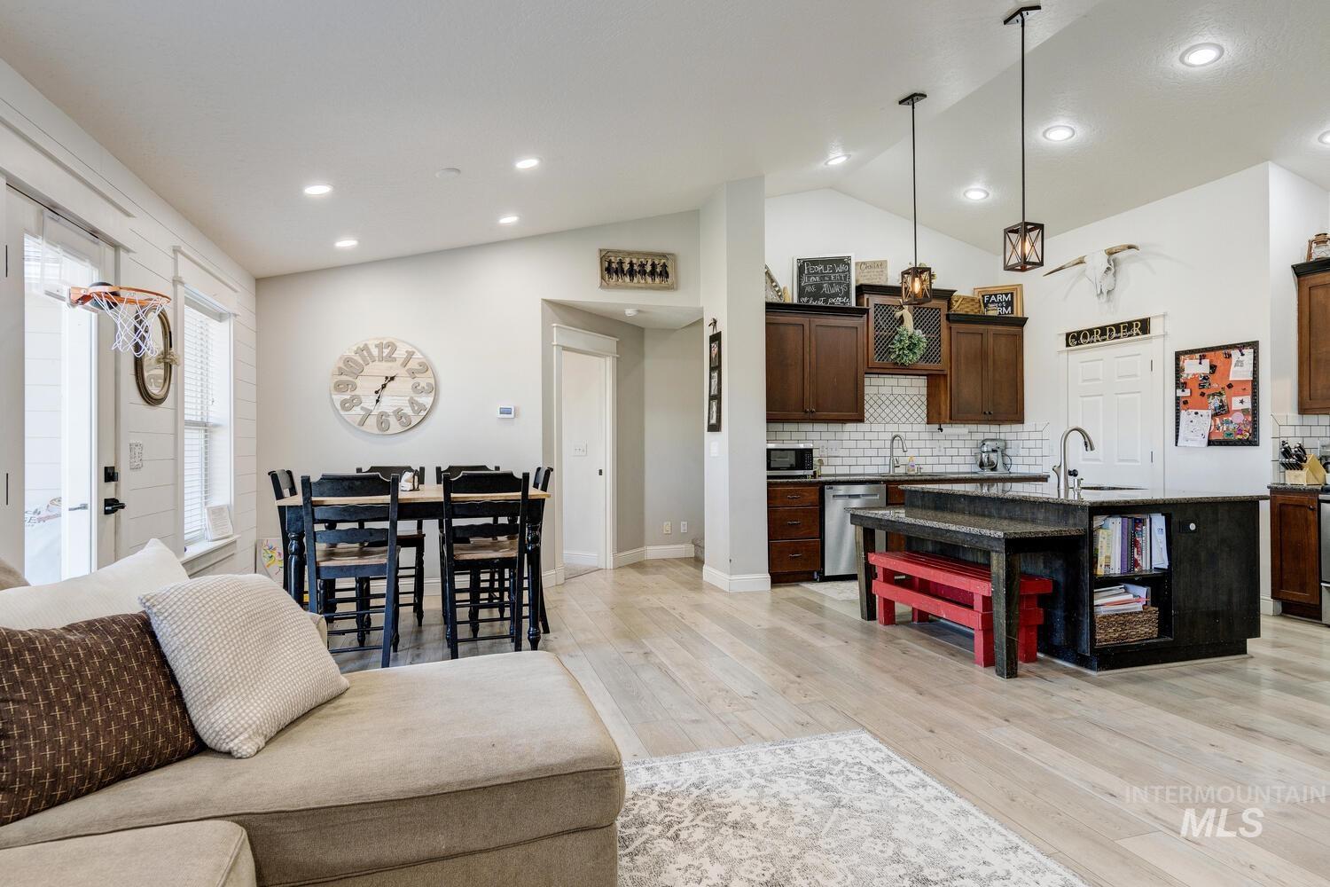 Living area with light wood-style floors, recessed lighting, and high vaulted ceiling