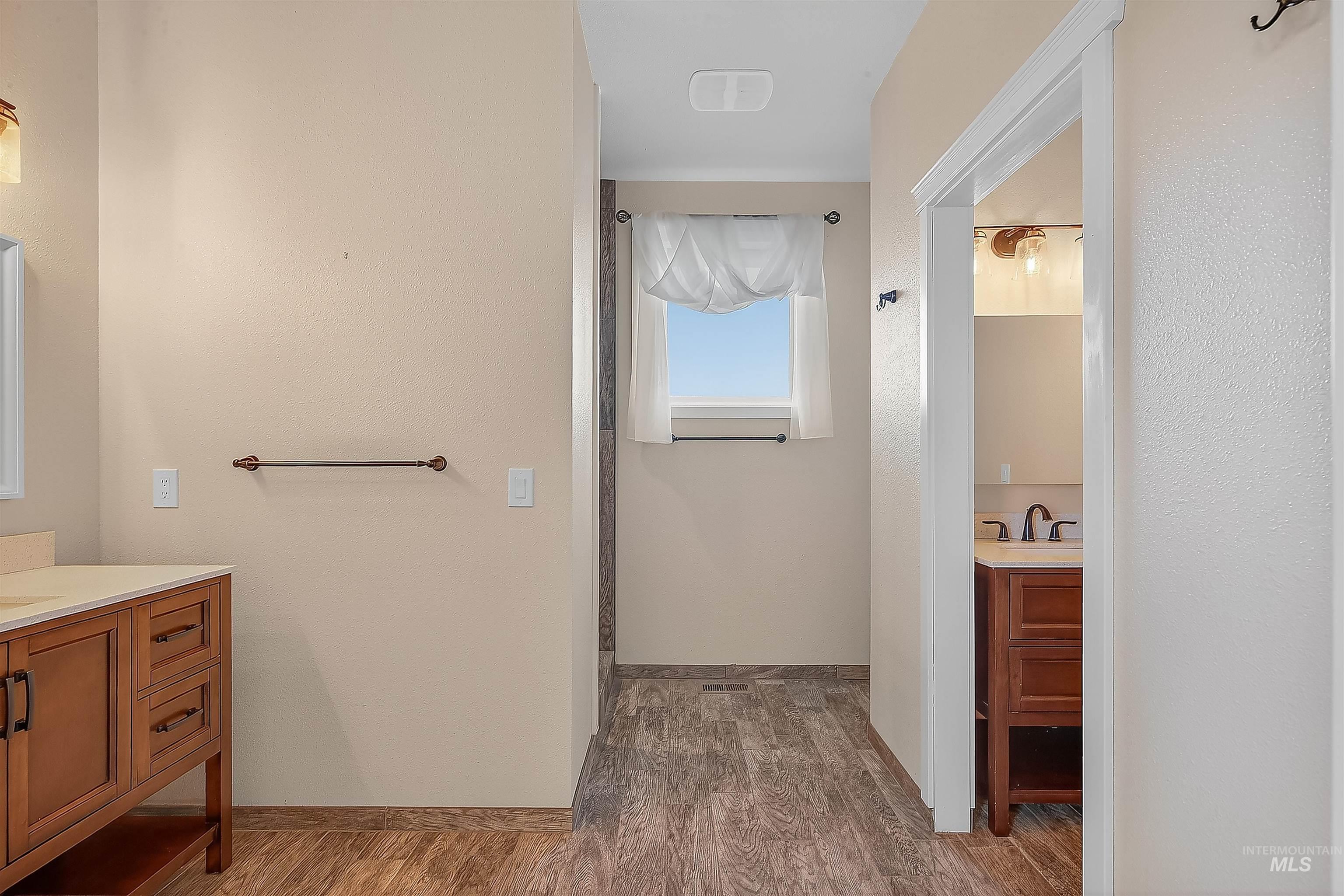 Bathroom featuring vanity and dark wood-style flooring