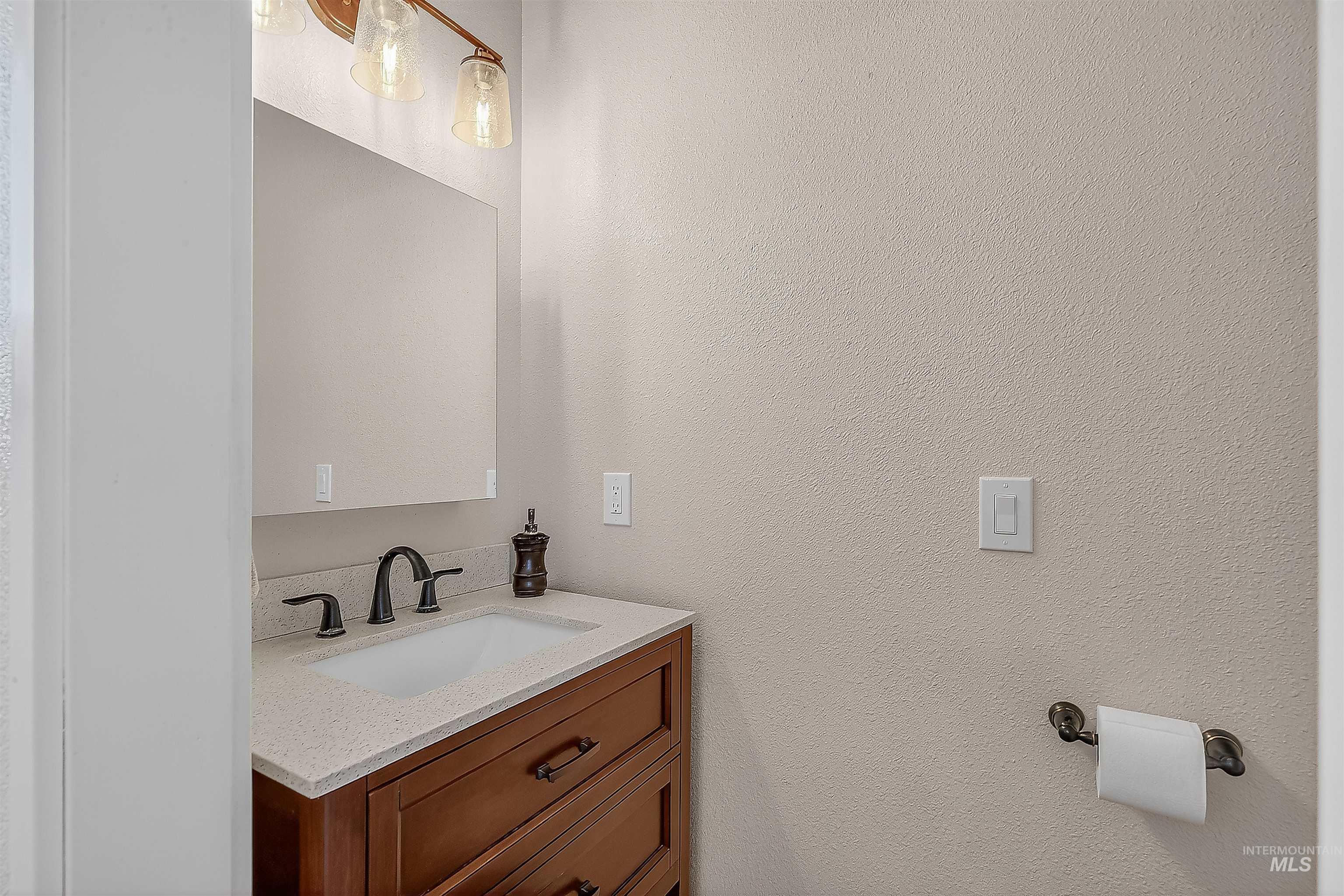Bathroom featuring vanity and a textured wall