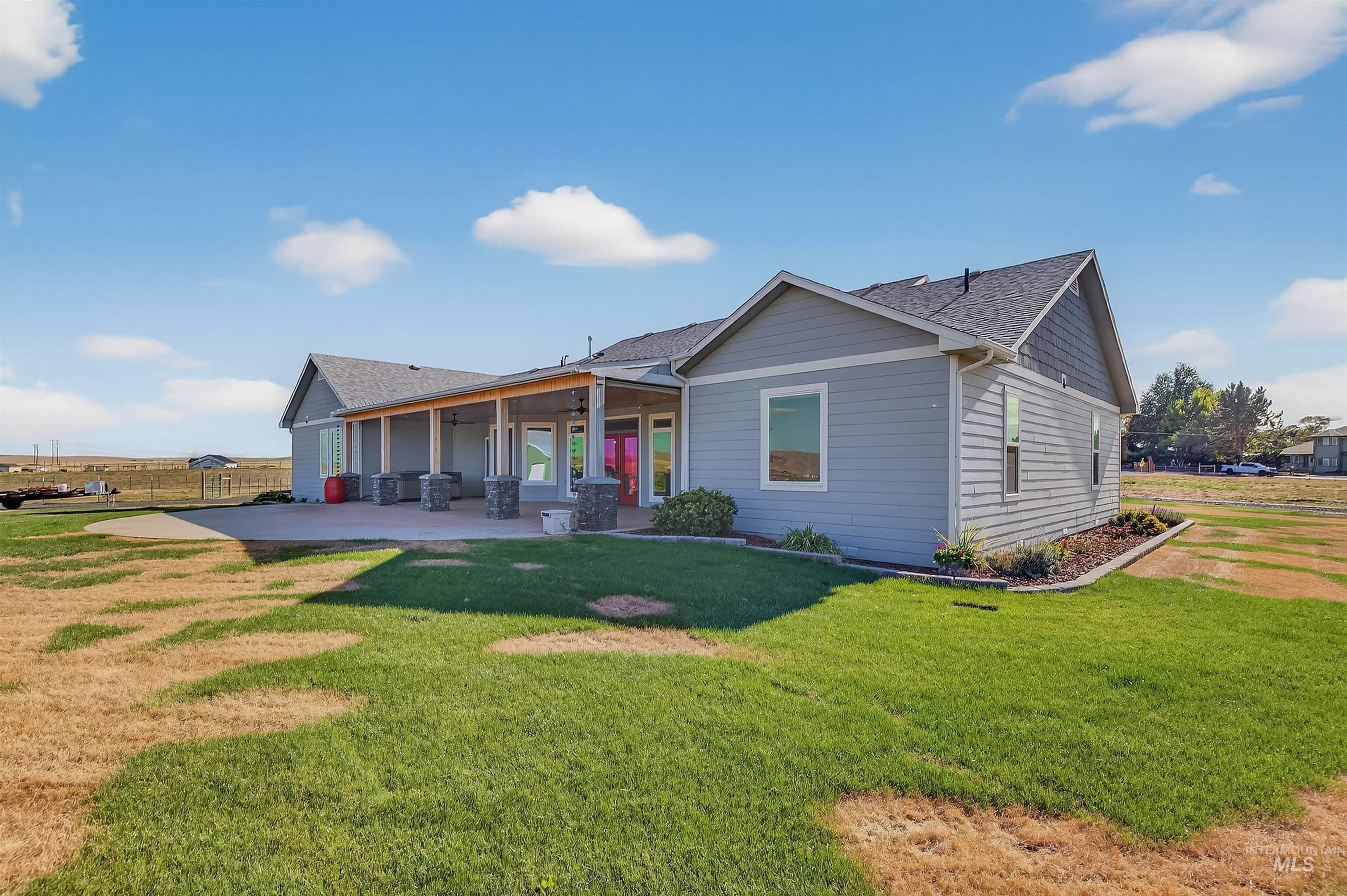 Back of house featuring a shingled roof, a patio area, a yard, and a ceiling fan