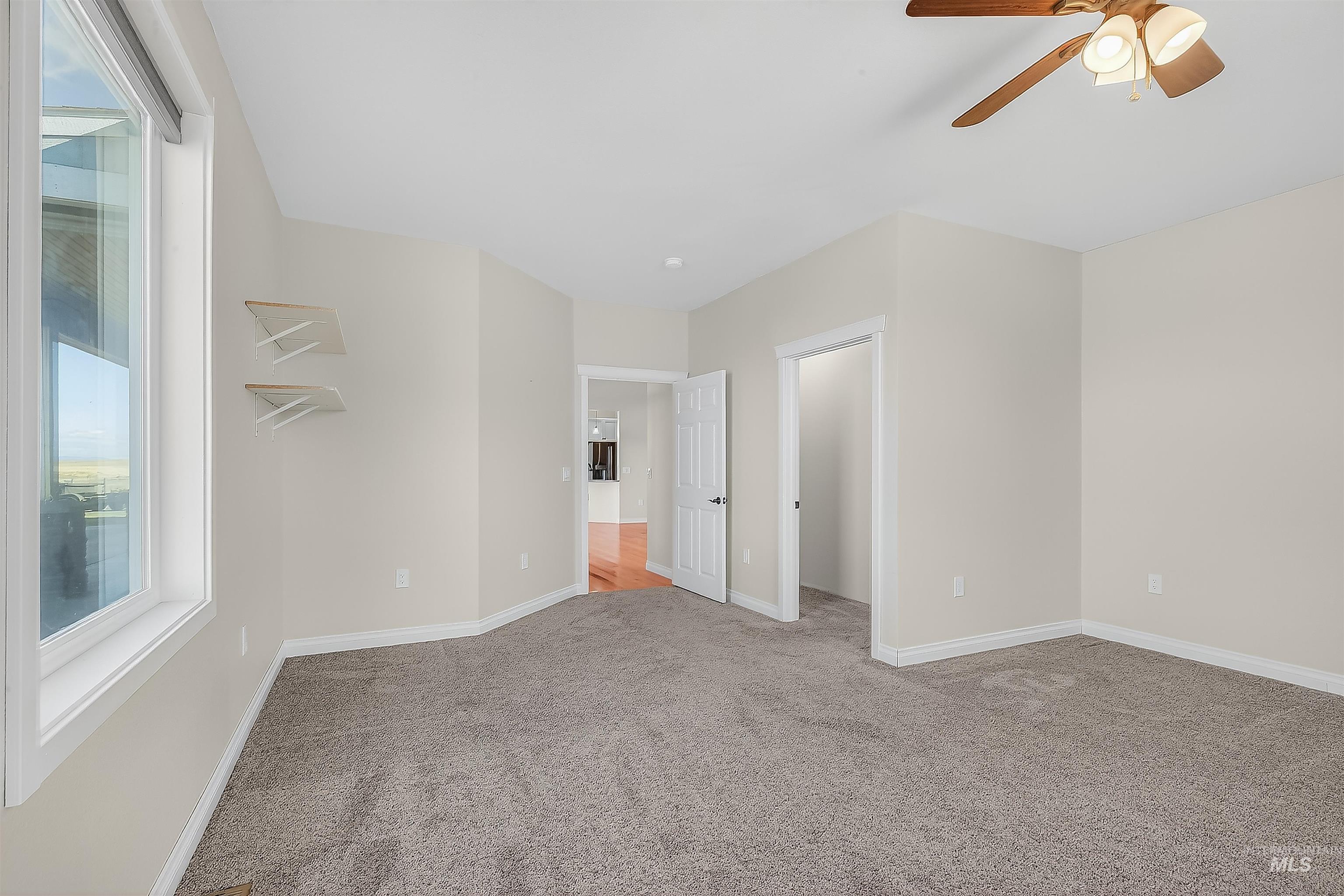 Unfurnished bedroom with light carpet and a ceiling fan