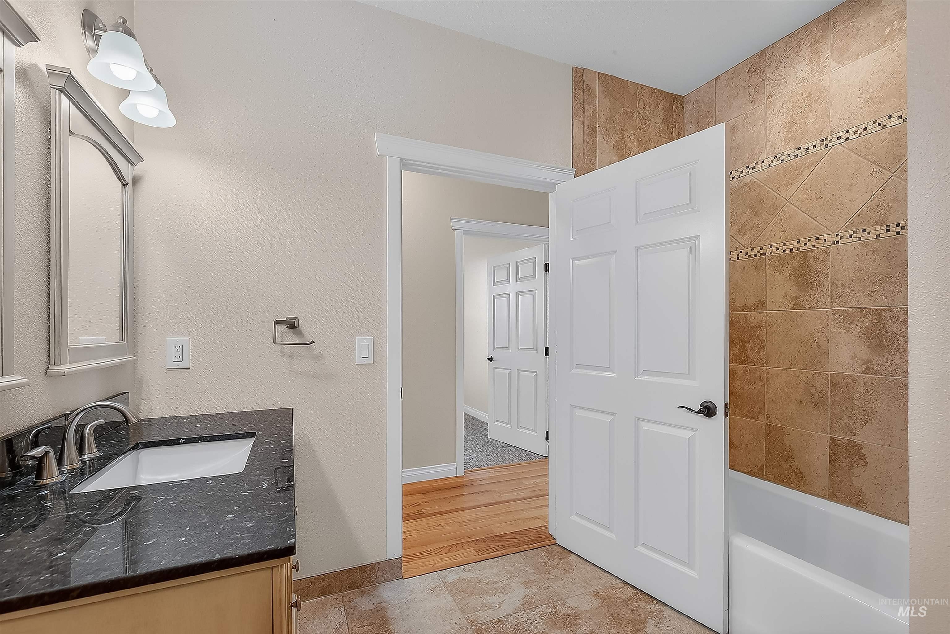 Full bathroom with vanity, shower / bath combination, and light tile patterned floors