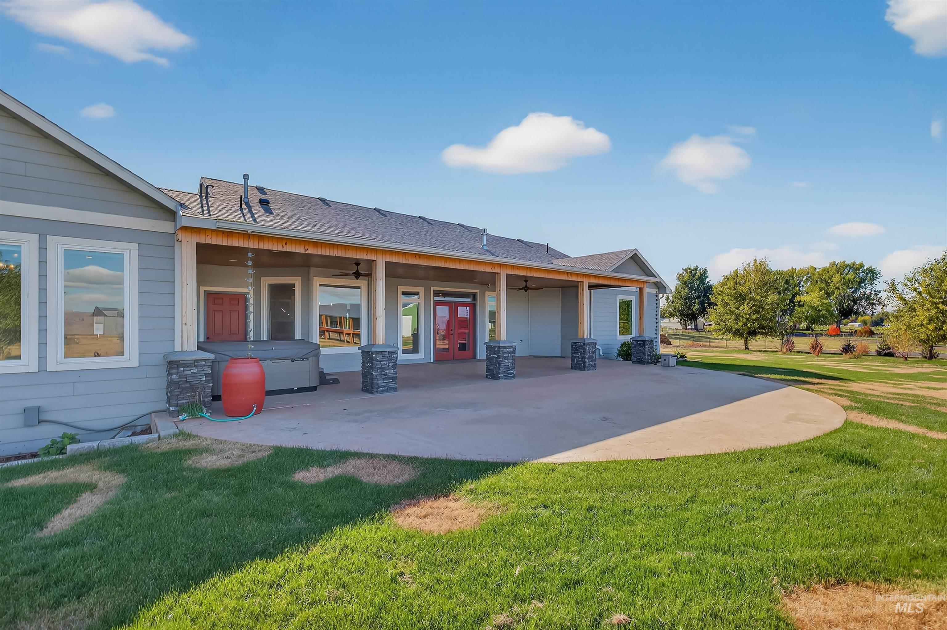 Rear view of house with a ceiling fan, a yard, french doors, and roof with shingles