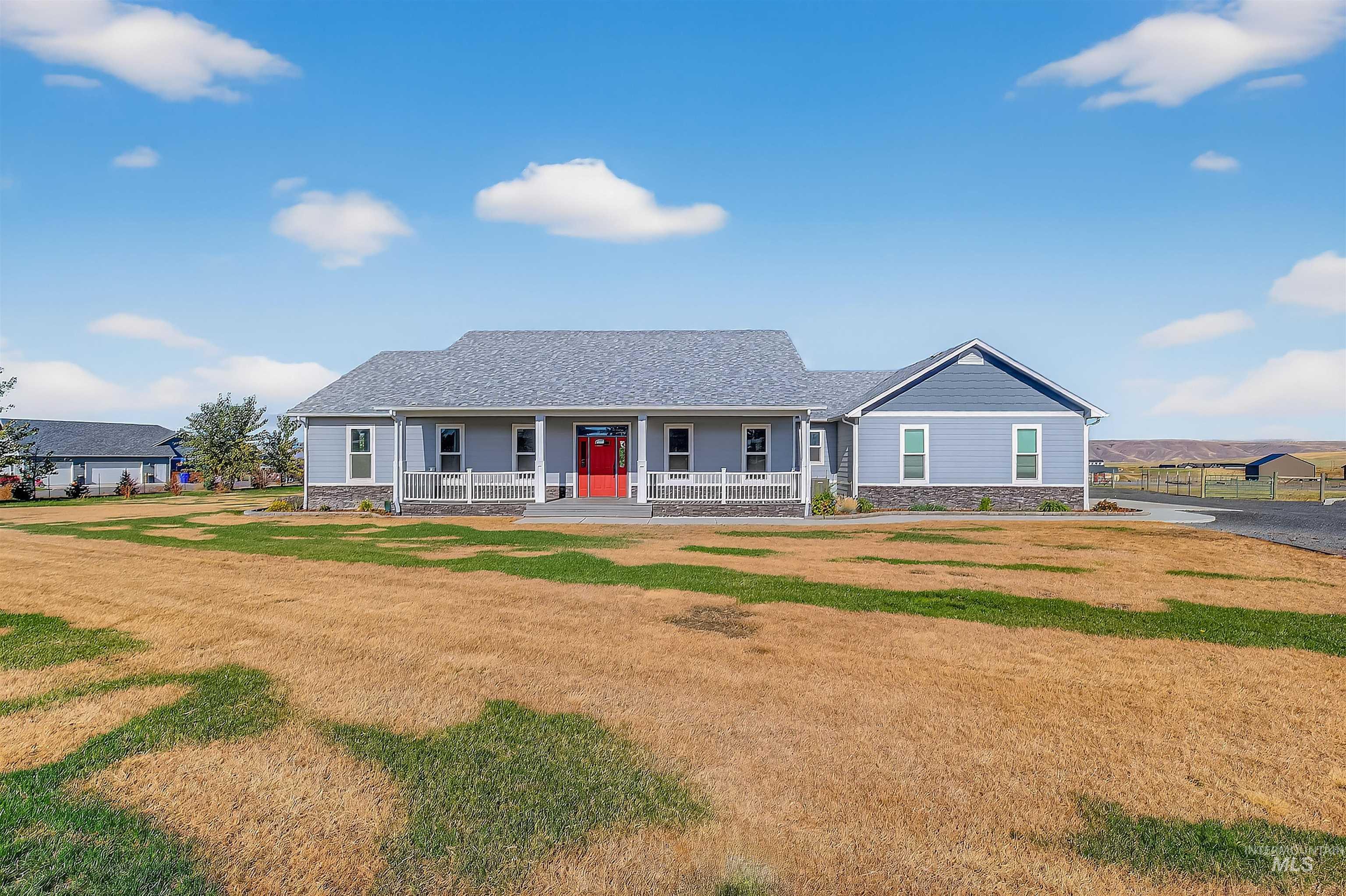 Ranch-style house with stone siding, a front lawn, covered porch, and a shingled roof