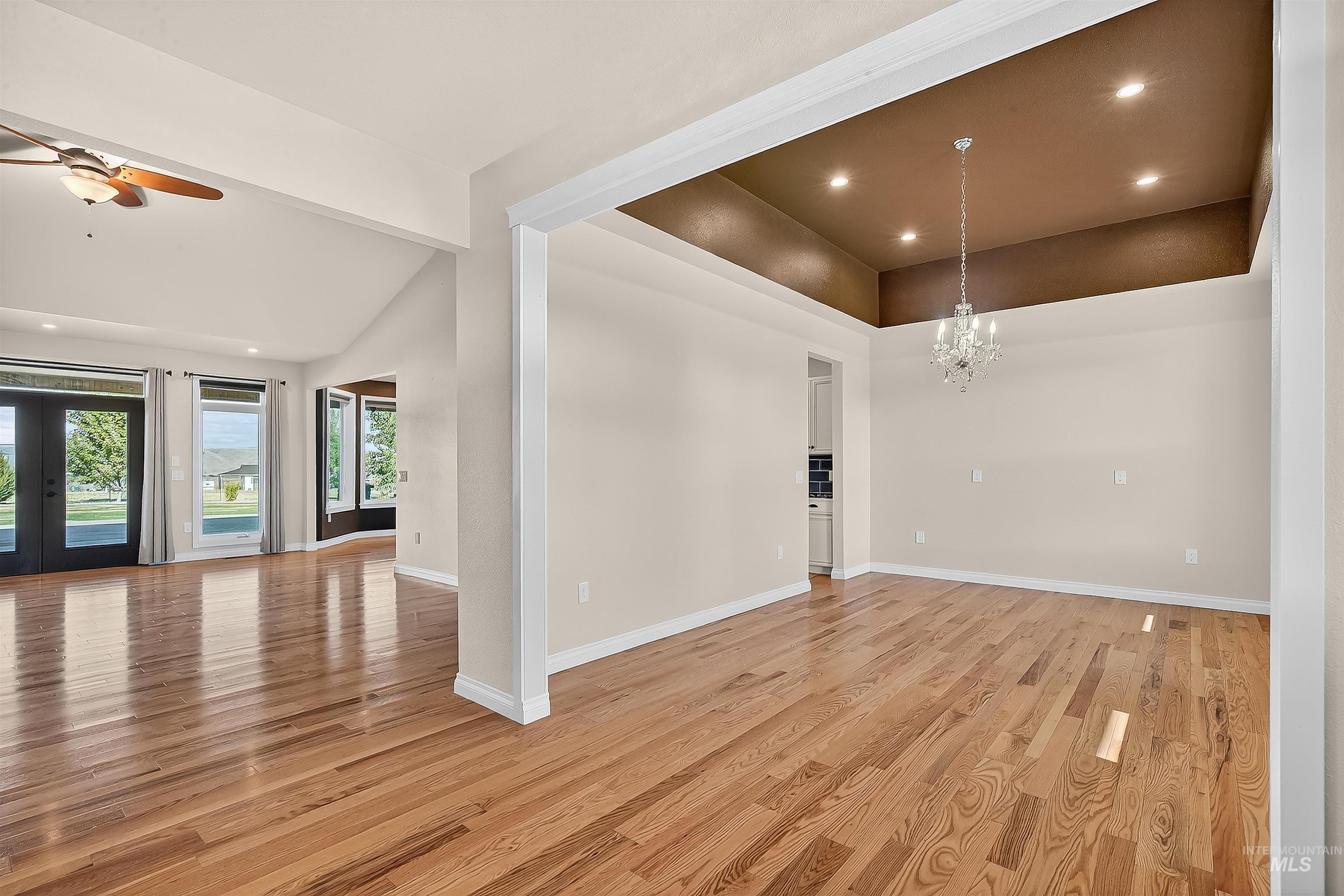 Empty room with recessed lighting, light wood-type flooring, a chandelier, a ceiling fan, and french doors