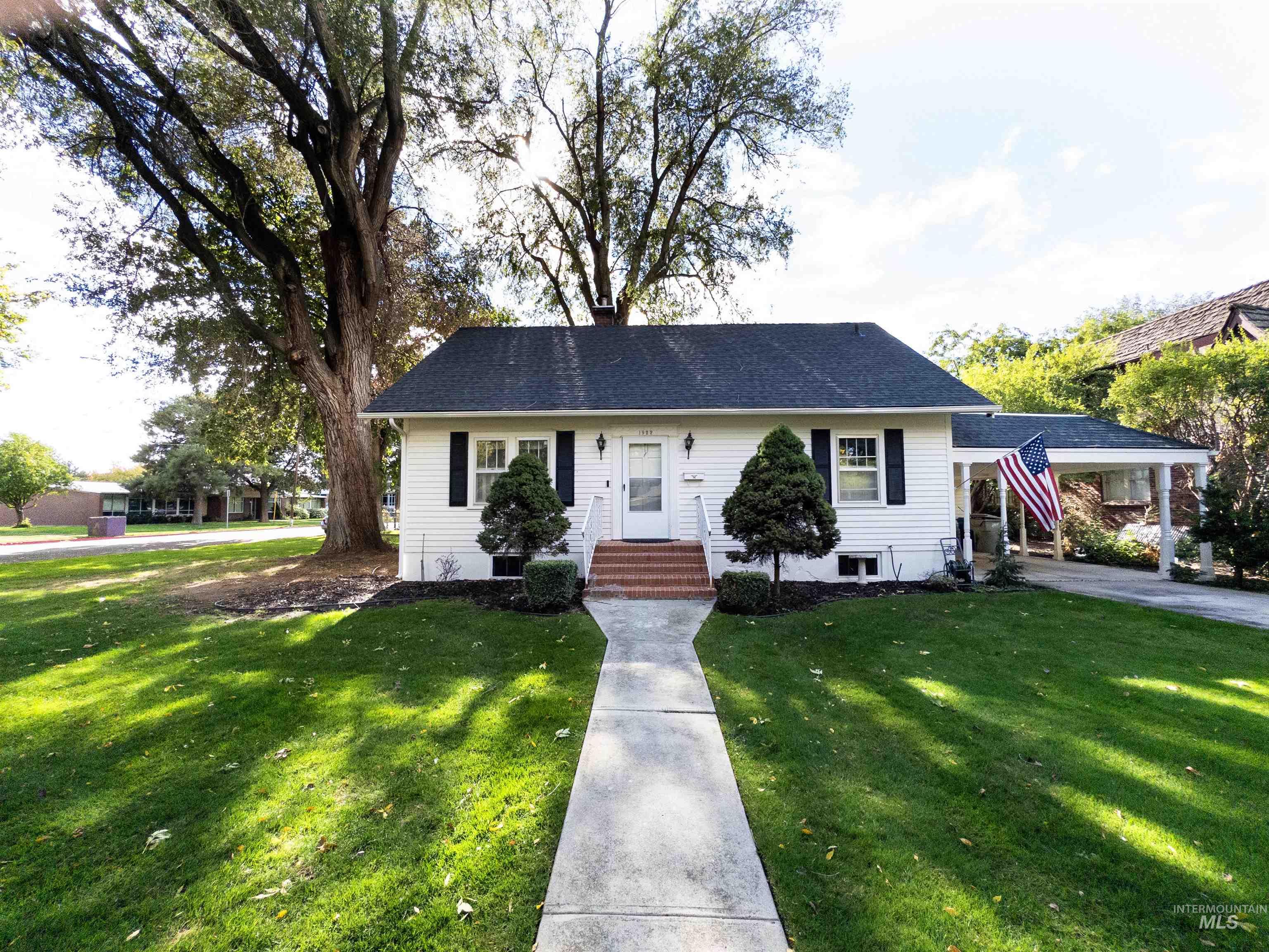 View of front of home featuring a front lawn and roof with shingles