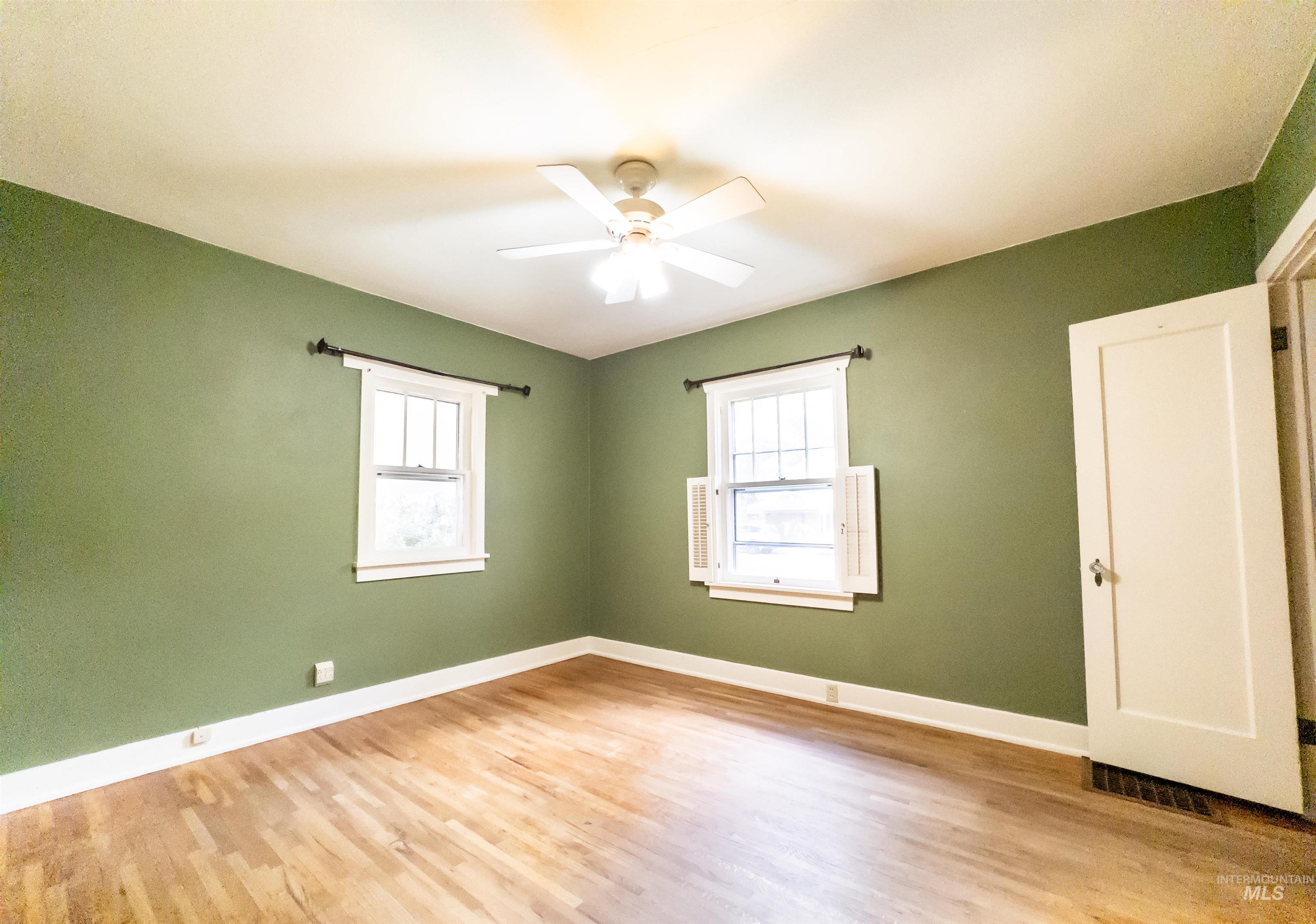 Empty room featuring light wood-type flooring and ceiling fan
