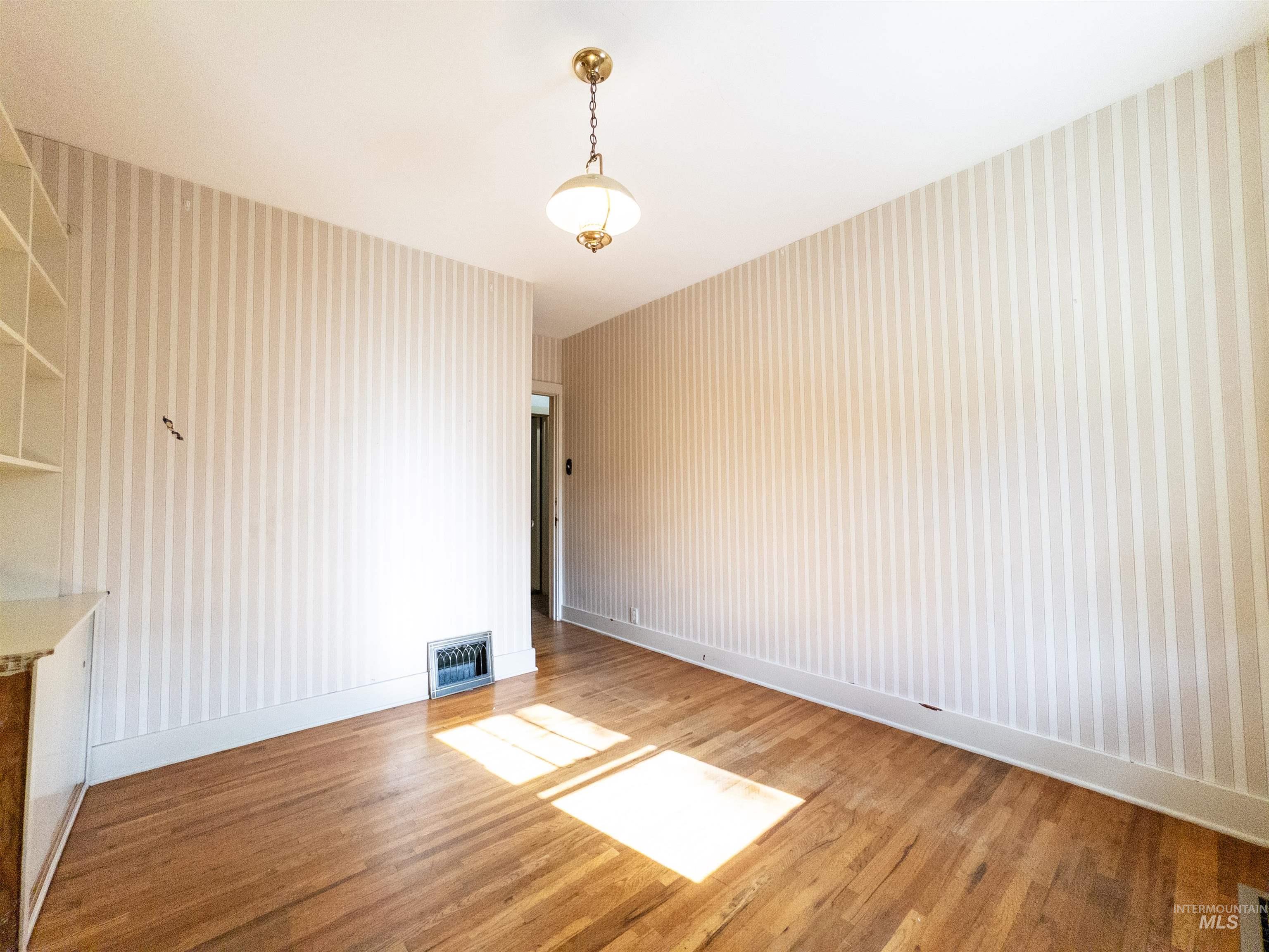 Unfurnished dining area with light wood-type flooring and baseboards