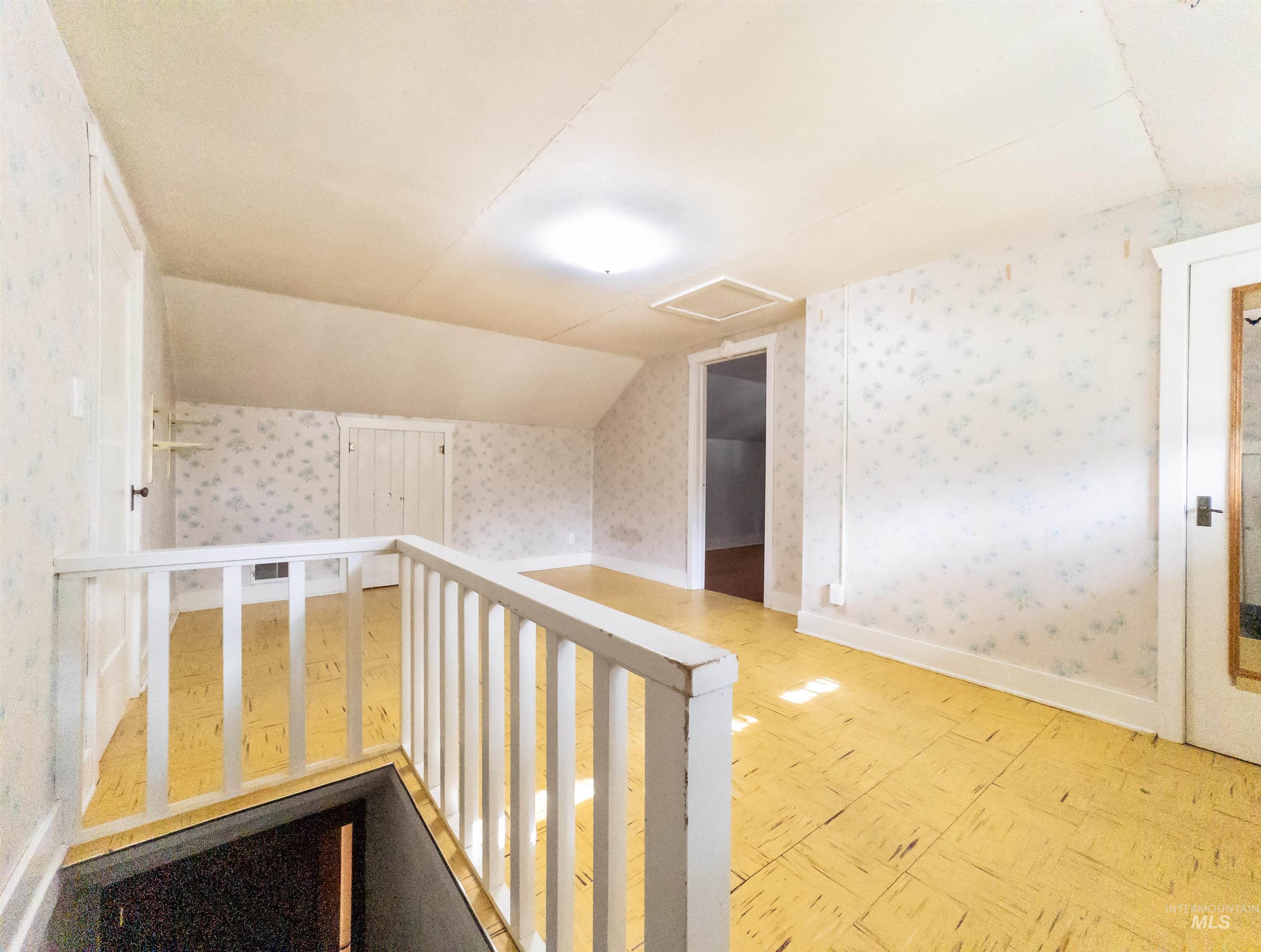 Bonus room featuring wallpapered walls, attic access, and vaulted ceiling