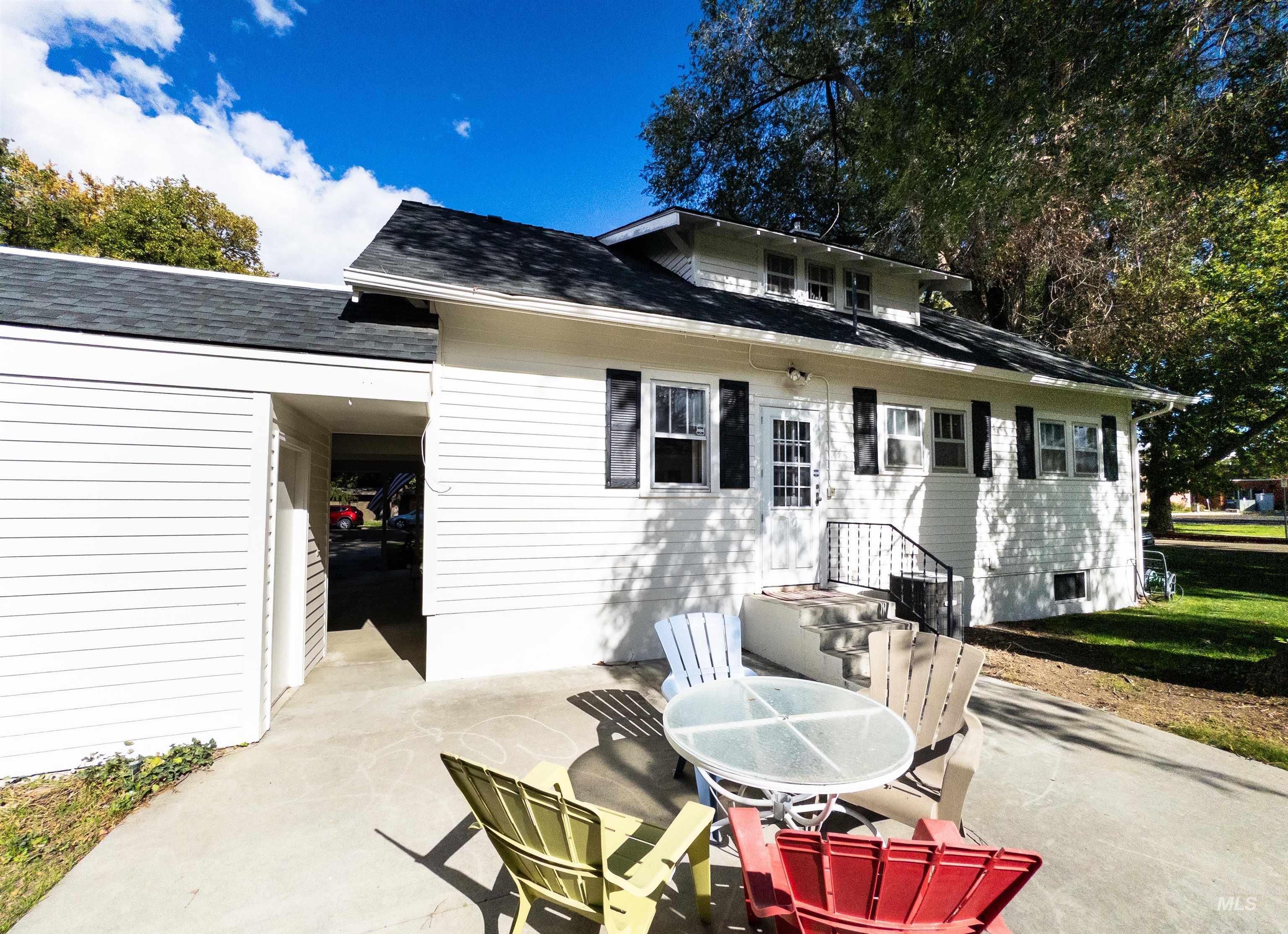 Rear view of property featuring a shingled roof and a patio area