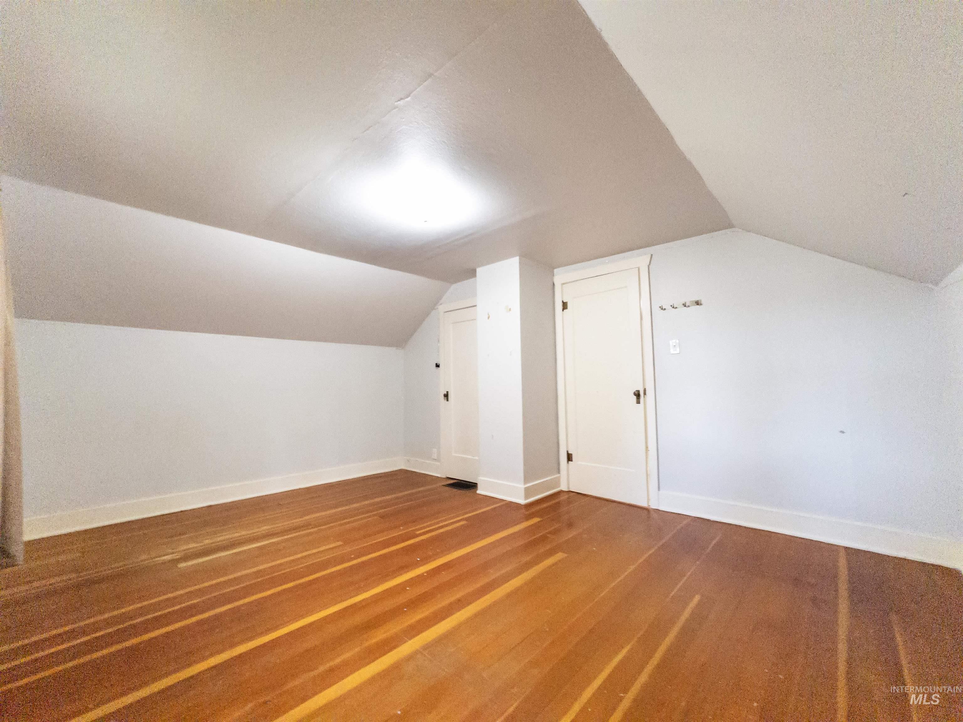 Bonus room with lofted ceiling and wood finished floors