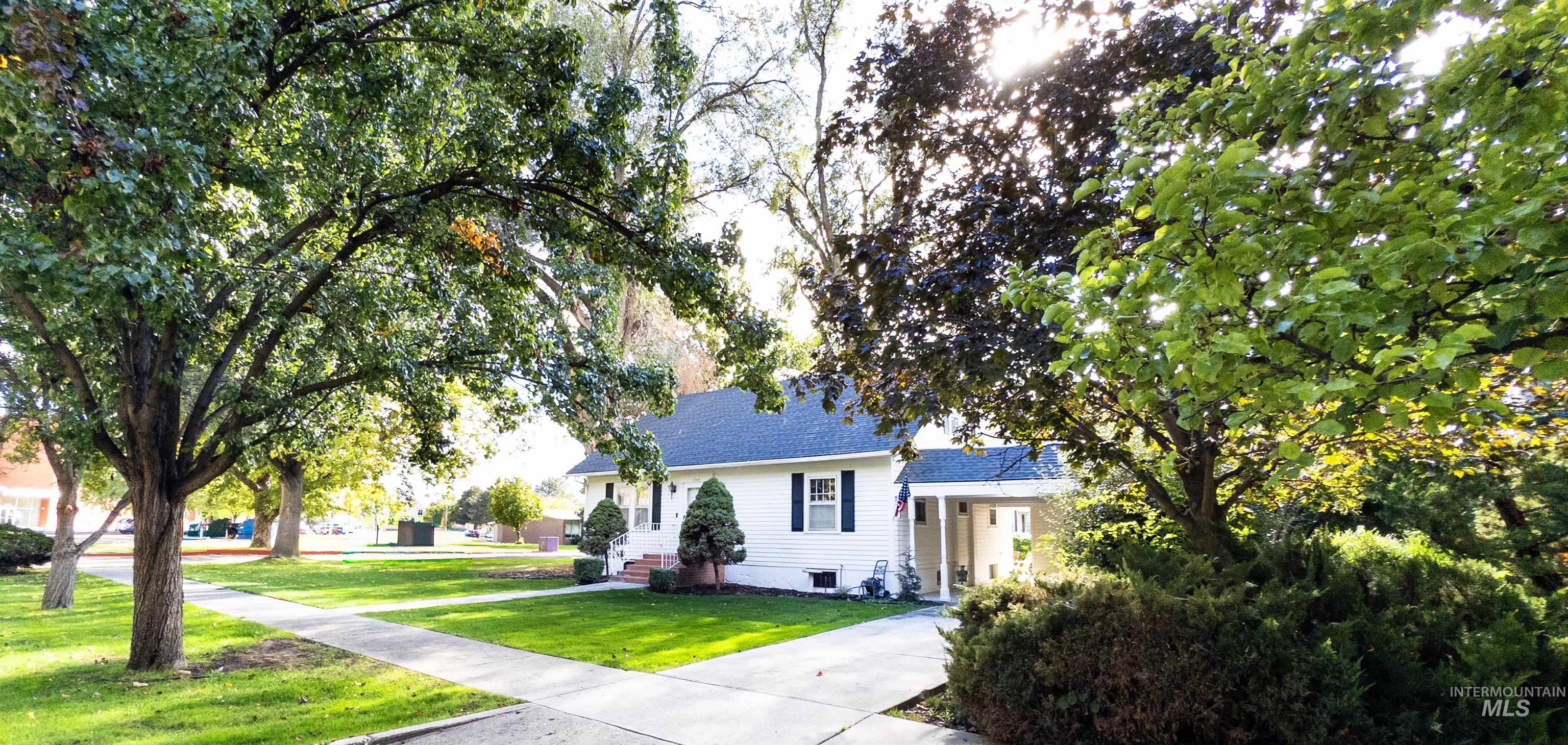 View of front facade with a front yard and a shingled roof