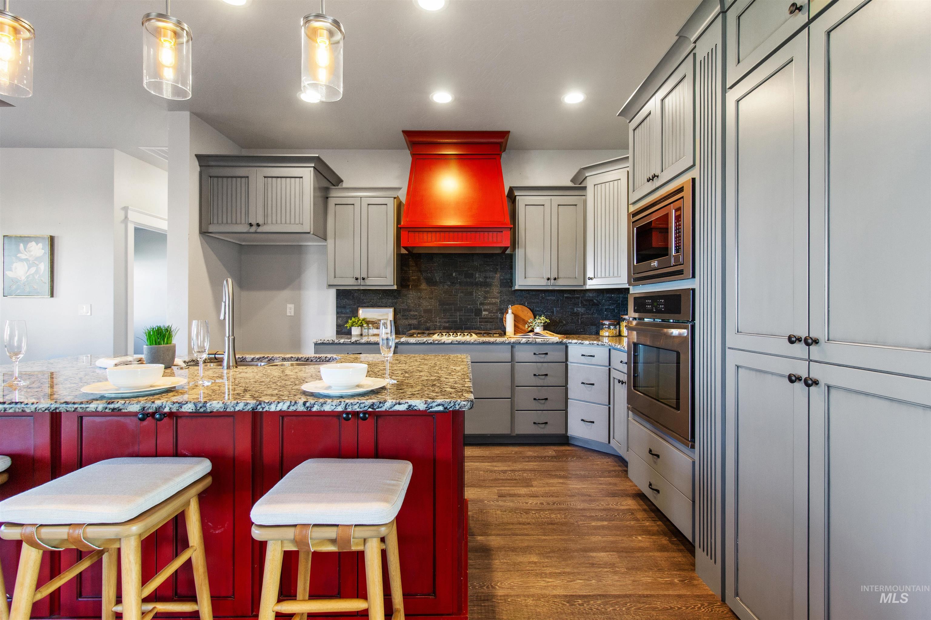 Kitchen with premium range hood, decorative backsplash, appliances with stainless steel finishes, recessed lighting, and dark wood-type flooring